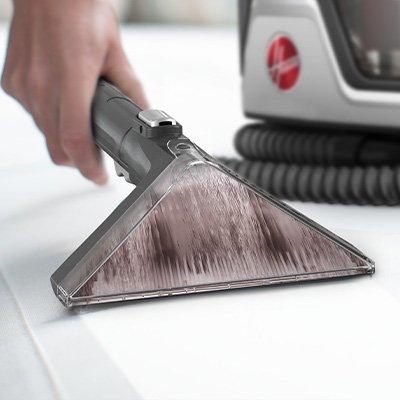 Hand shown using the Cleanslate pet carpet spot cleaner with the 7in wide path tool on a white surface demonstrating its deep cleaning capability