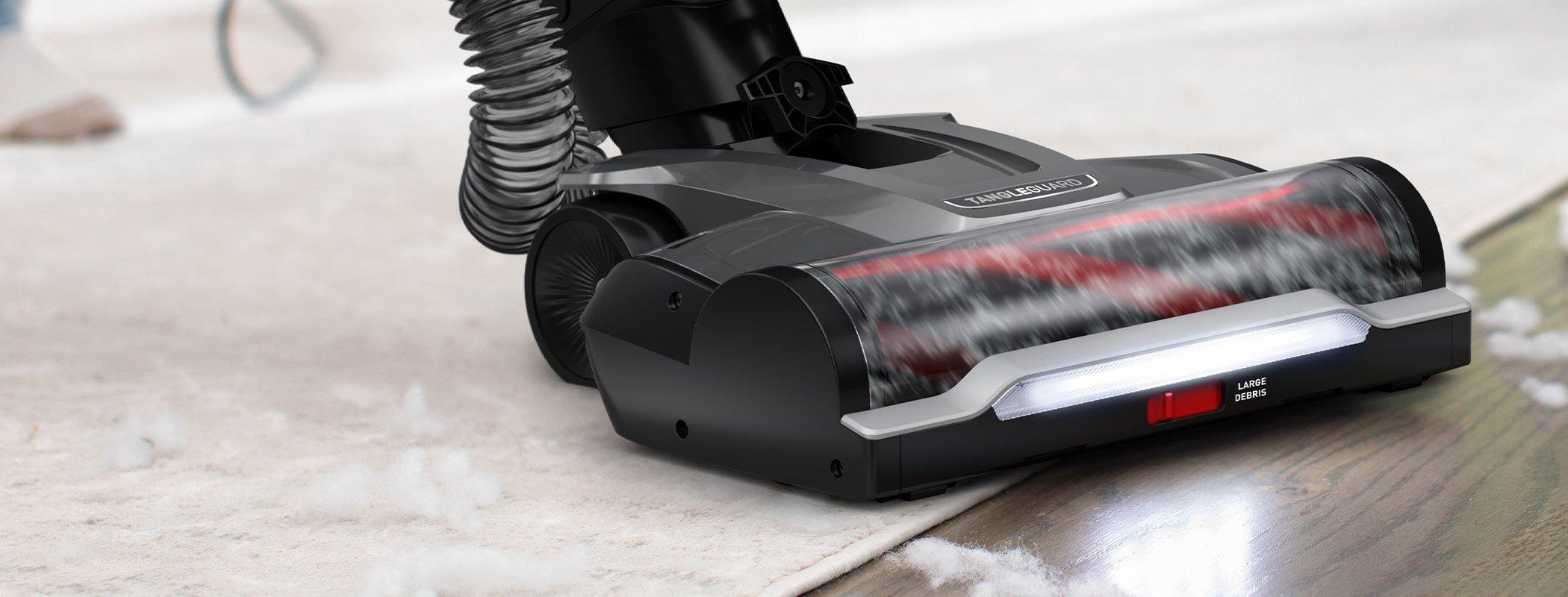 Hoover vacuum cleaner with tangleguard technology and powerful suction in action, efficiently cleaning cotton from a hard floor and area rug.