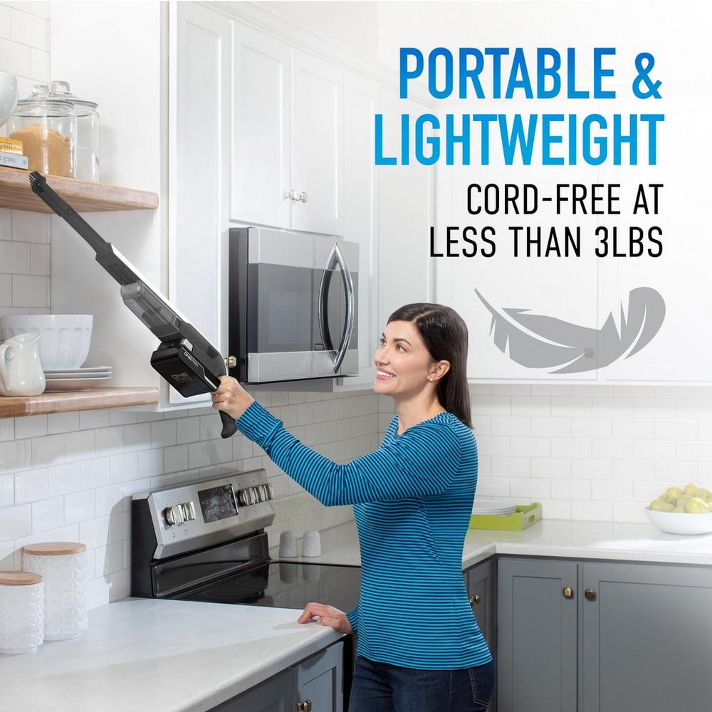 Woman using a lightweight, cordless Hoover vacuum cleaner to reach high kitchen shelves, with text emphasizing 'Portable & Lightweight, cord-free at less than 3lbs,' highlighting the product's ease of use and mobility.