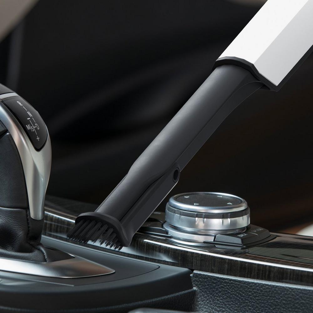 Close-up. of a 2-in-1 dusting crevice tool cleaning a car's interior, highlighting its versatility for dusting and reaching tight spaces.