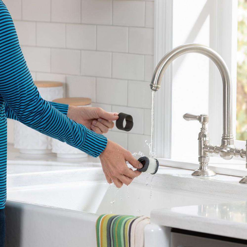 Person rinsing a vacuum filter under a faucet, highlighting the washale and reusable filter feature.