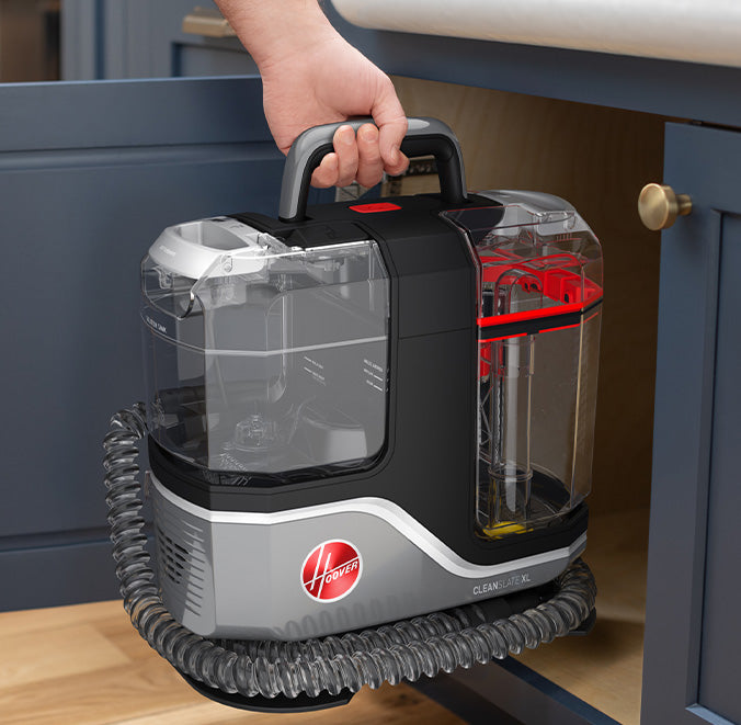 Hoover cleanslate xl being placed in a kitchen cabinet showcasing its collapsible handle and compact design for easy storage