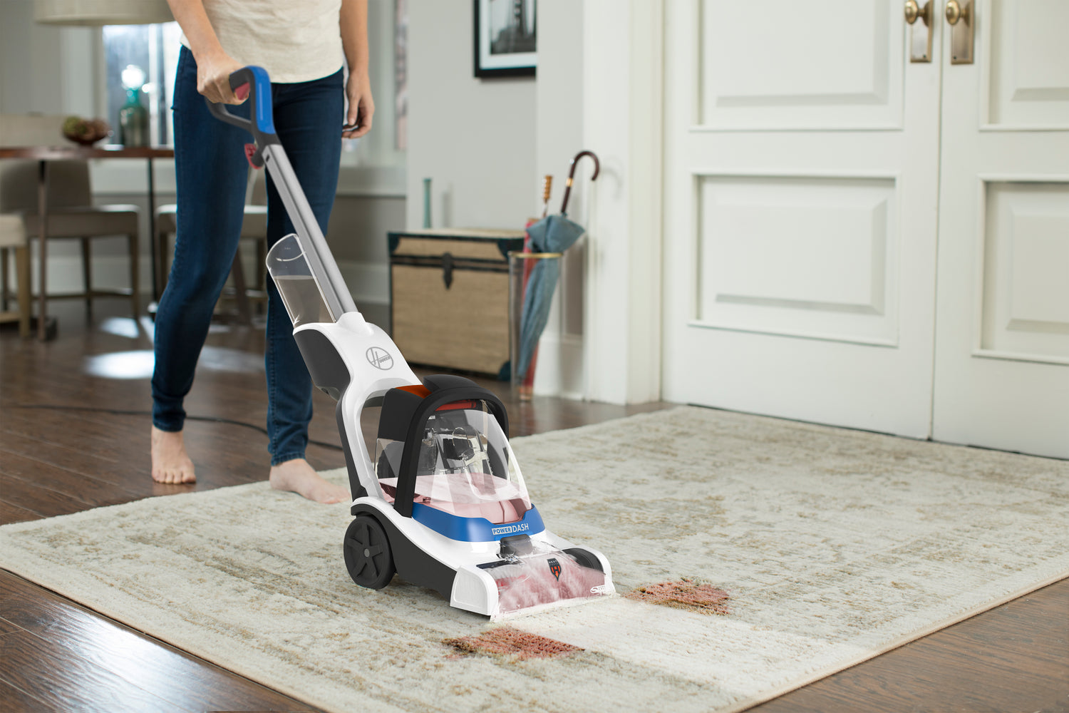 person uses powerdash pet compact carpet cleaner to clean up red stain on grey rug