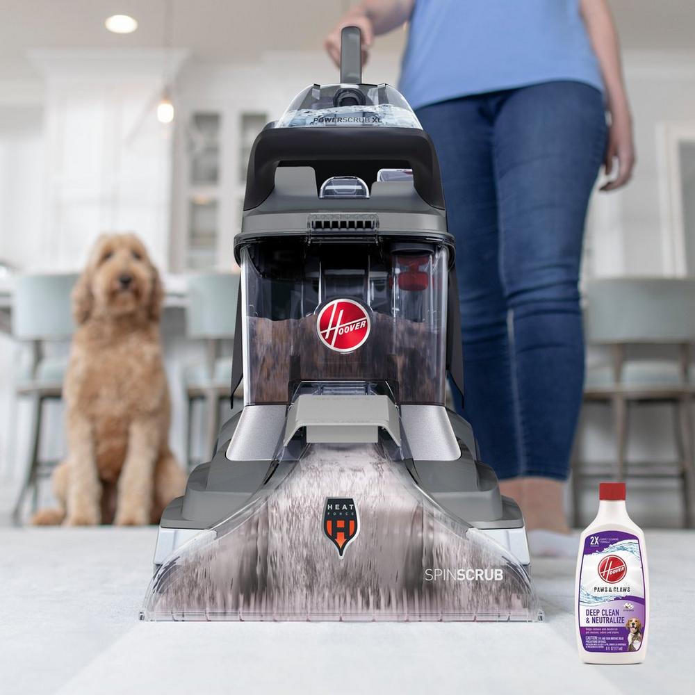 Hoover carpet cleaner with HeatForce technology in a living room, alongside a bottle of Deep Clean & Neutralize solution, perfect for removing pet stains, with a dog in the background.