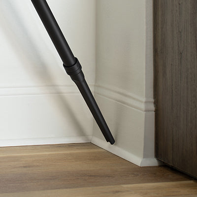 Hoover vacuum cleaner crevice attachment tool being used to clean a corner and baseboard area.