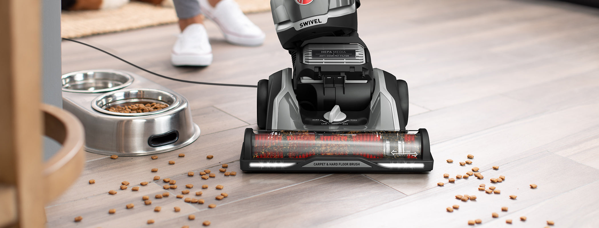 Hoover high performance swivel xl vacuum cleaner in action effectively vacuuming pet food from hard wood floor
