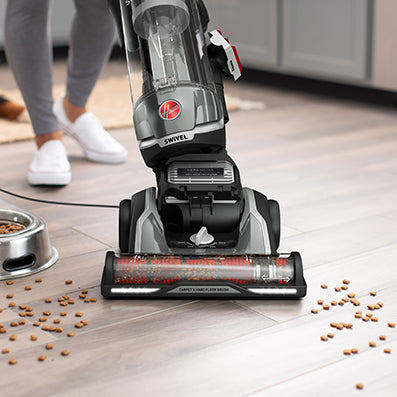 Hoover high performance swivel xl vacuum cleaner in action effectively vacuuming pet food from hard wood floor