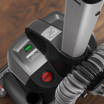 Top down close up of the control panel on a Hoover vacuum cleaner, highlighting the power button and cord rewind features for convenient operation.