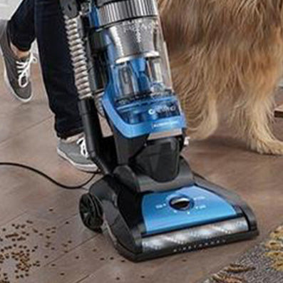Close up of the Hoover rewind actively cleaning pet food spills on a hardwood floor