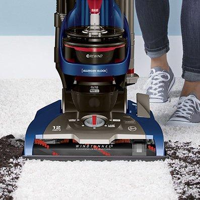 Close up of Hoover whole house rewind vacuum cleaner effectively cleaning up dirt and debris from a white carpet