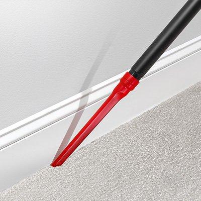 Hoover crevice tool being used to vacuum baseboards, highlighting its ability to clean hard-to-reach areas.