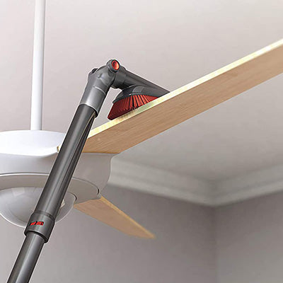 Using a Hoover vacuum cleaner's extendable wand to easily dust and clean high, hard to reach places like ceiling fans
