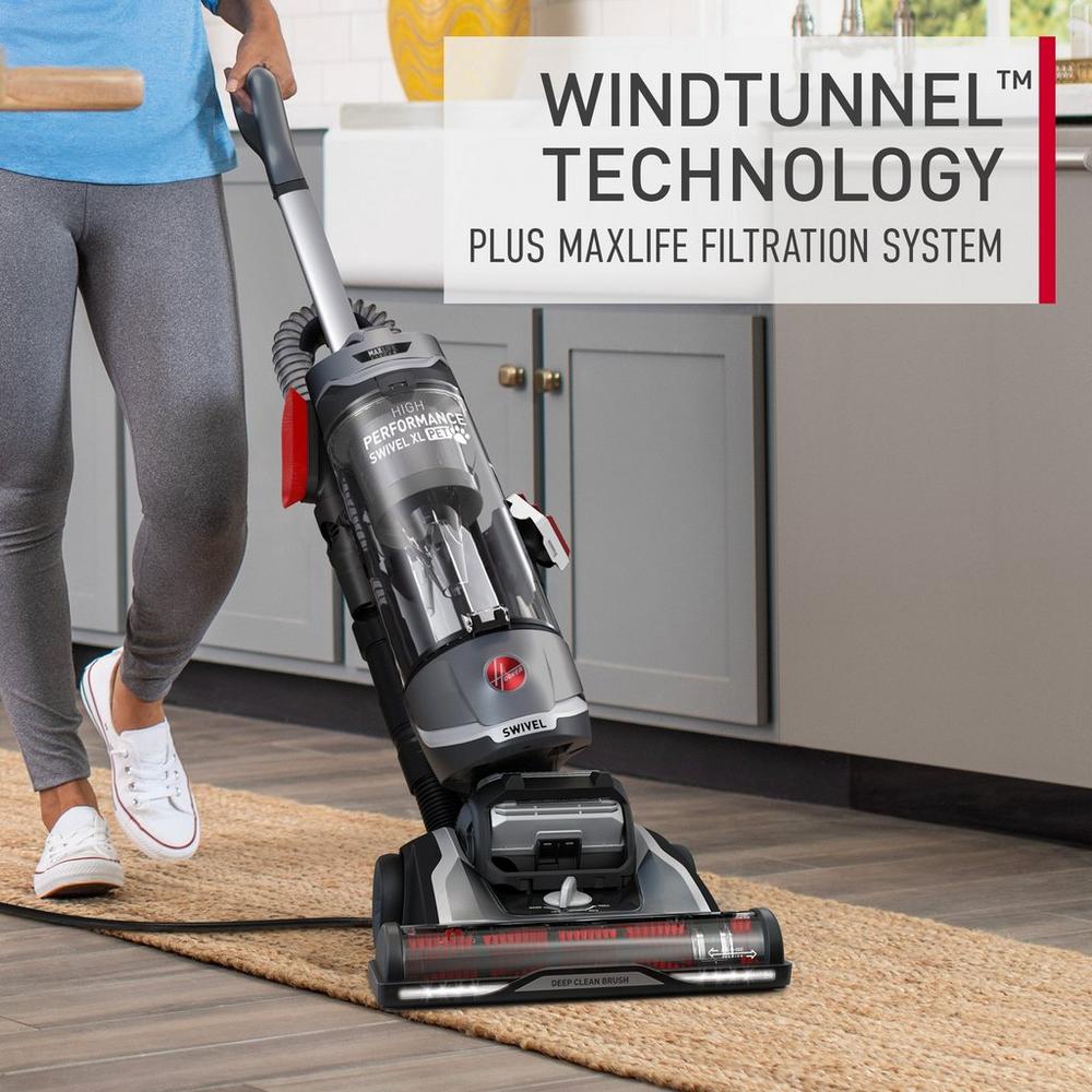 Hoover vacuum cleaner with windtunnel technology and maxlife filtration system is being used to vacuum a woven area rug.