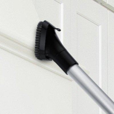 Hoover vacuum cleaner with extended reach wand and dusting brush attachment cleaning a high surface, highlighting extended reach capability