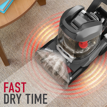 Hoover carpet cleaner emphasizing fast dry time, showcasing the cleaning head with visible dirt and a transparent tank, set against a textured carpet backdrop with a modern coffee table.