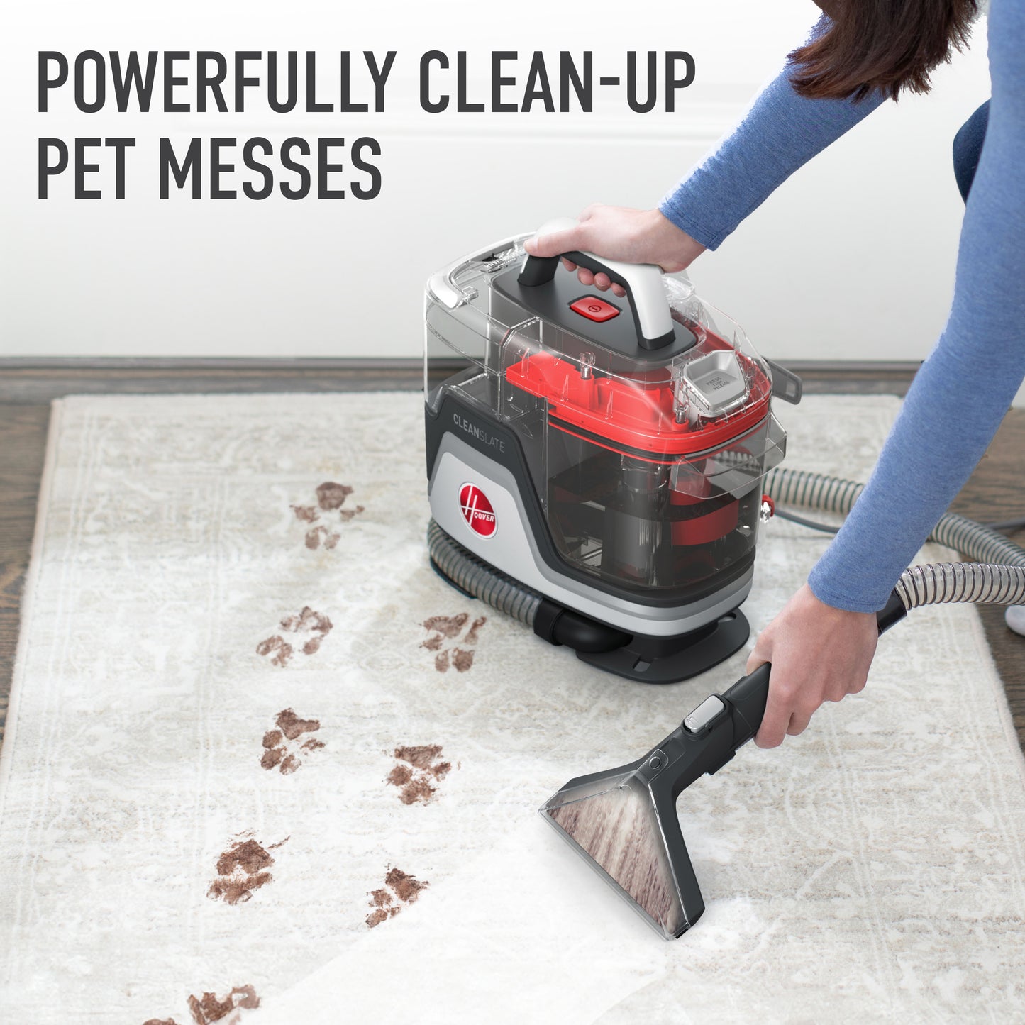 Woman shown using her cleanslate pet to spot clean paw prints off a light gray area rug