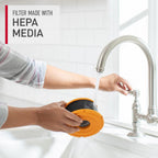 Cleaning hepa filter under a faucet.  The text states the filters are made with hepa media, highly efficient in capturing allergens and fine particles.  