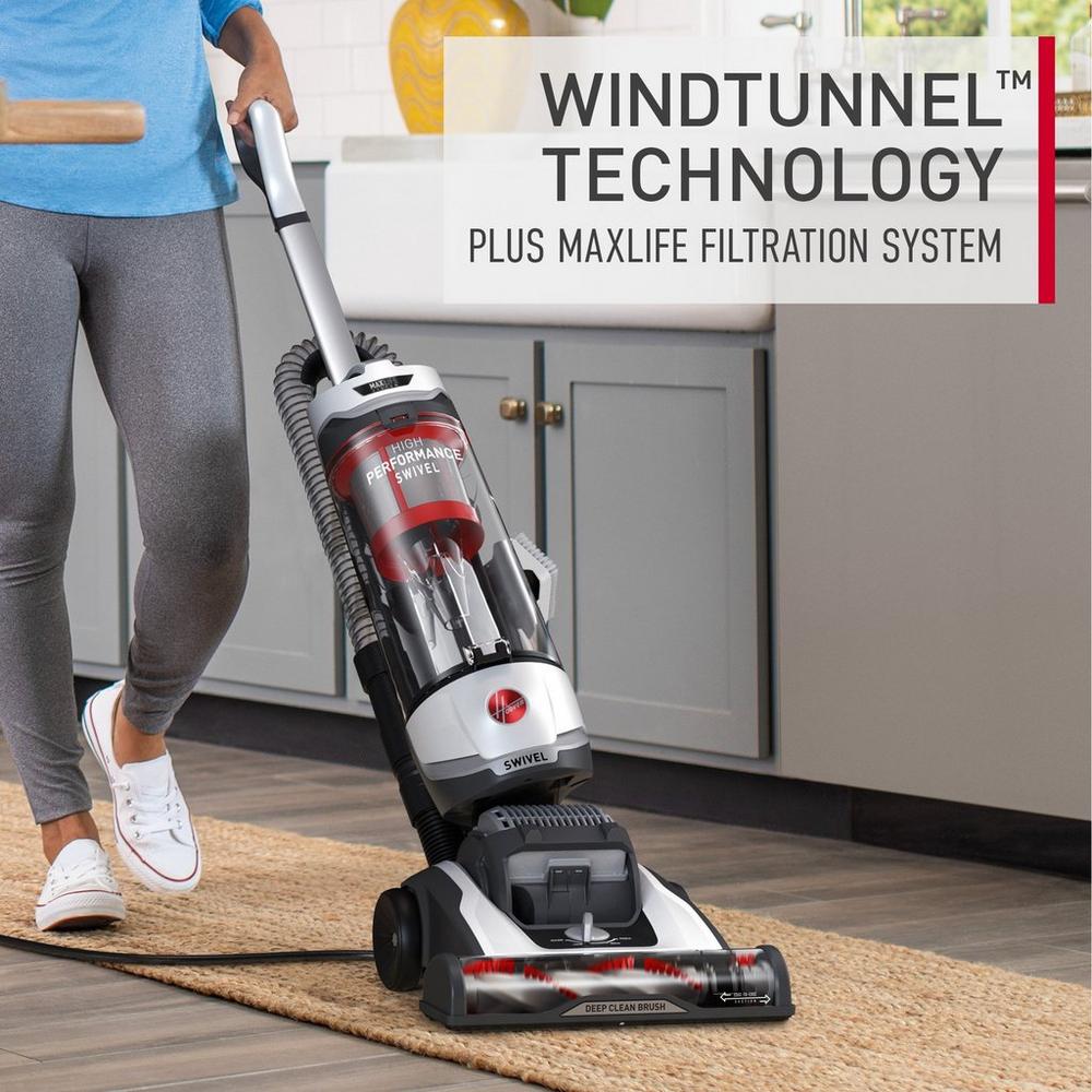 Hoover vacuum cleaner being used on a flat woven area rug showcasing its windtunnel technology and maxlife filtration system.  